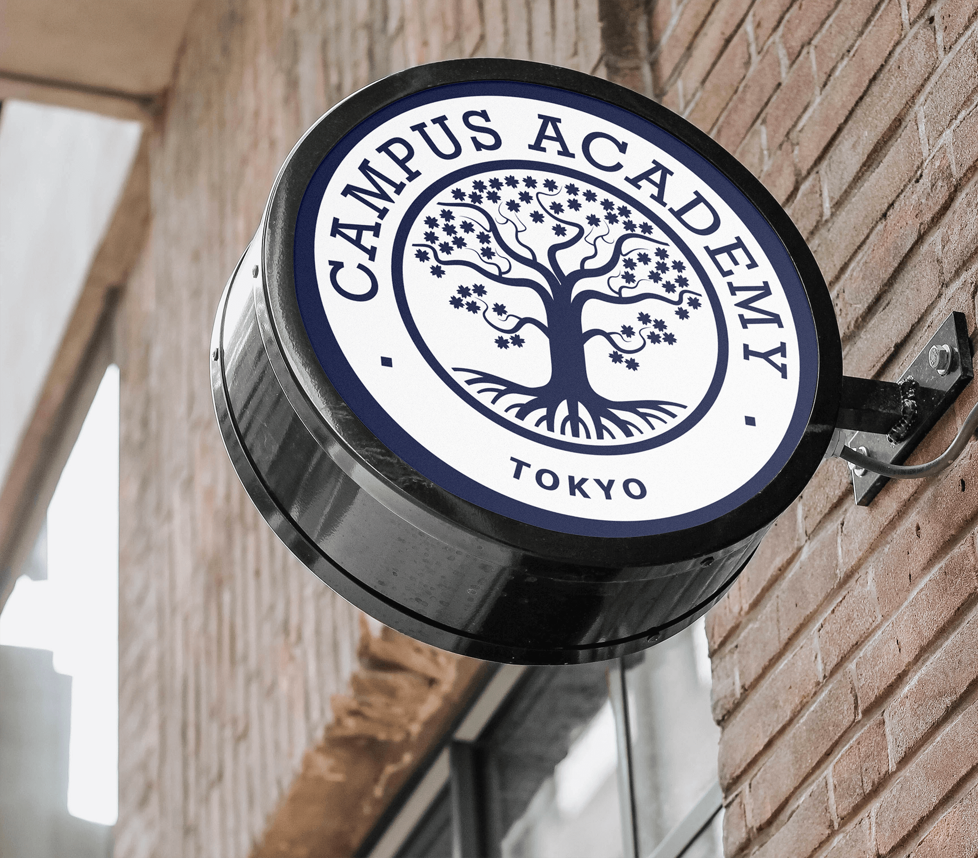 Enseigne ronde en métal accroché à un mur de briques et représentant le logo du campus.